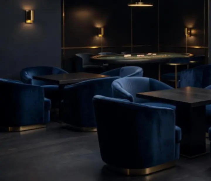 Prywatny, przyciemniony salon z welurowymi fotelami i stołem kasynowym dla członków klubu Salon Spotkań.